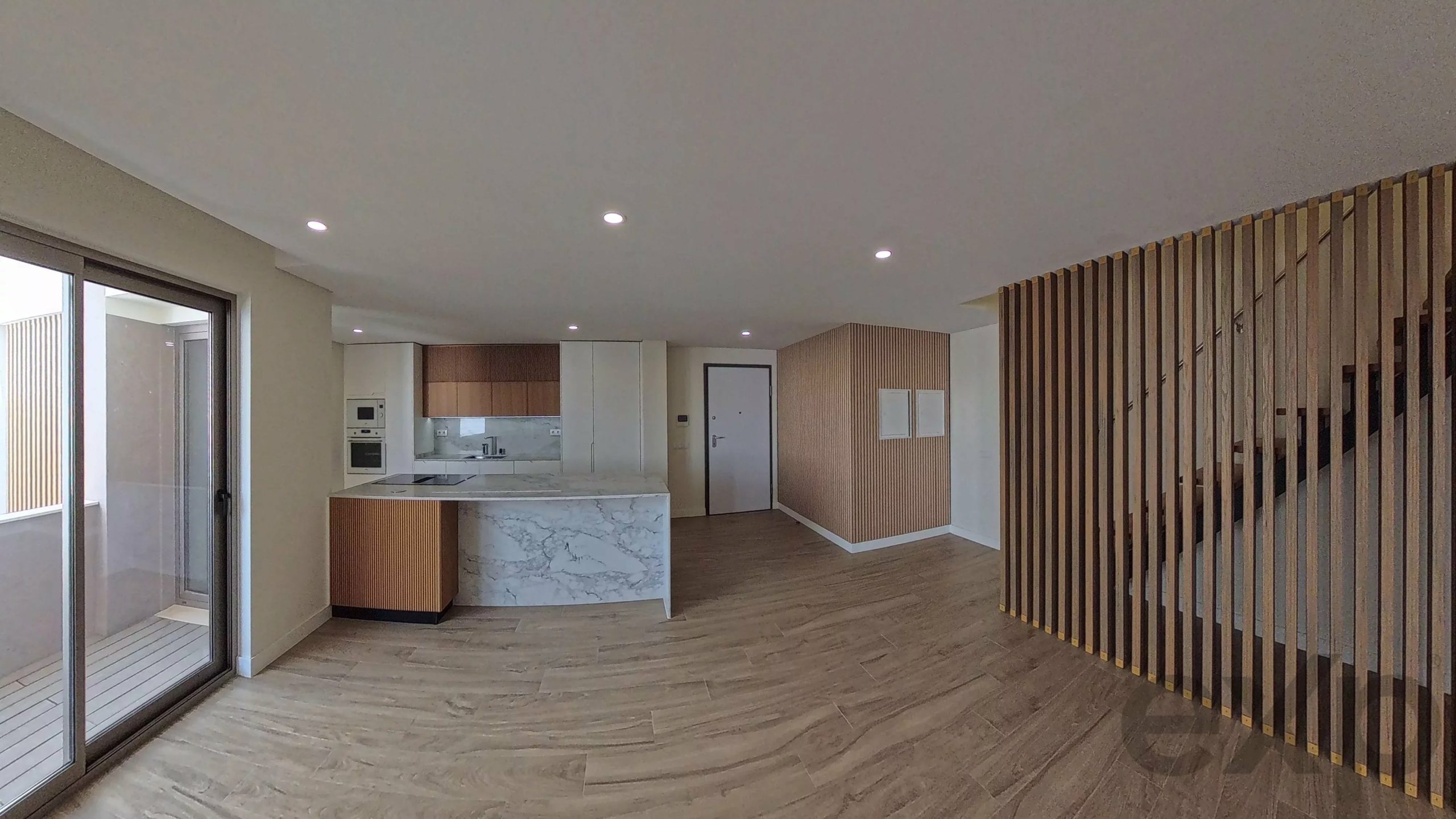 Open-plan living area with marble-topped kitchen island, wood cabinets, and a vertical slatted divider on the right.
