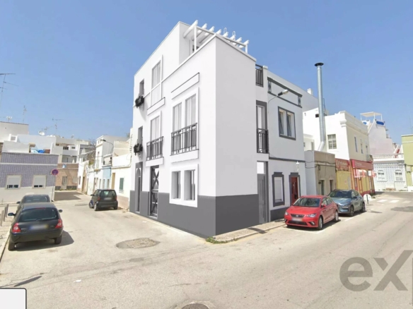 White corner building with multiple windows and small balconies on a sunny urban street, neighboring pastel houses under a clear blue sky (architectural render/edit).