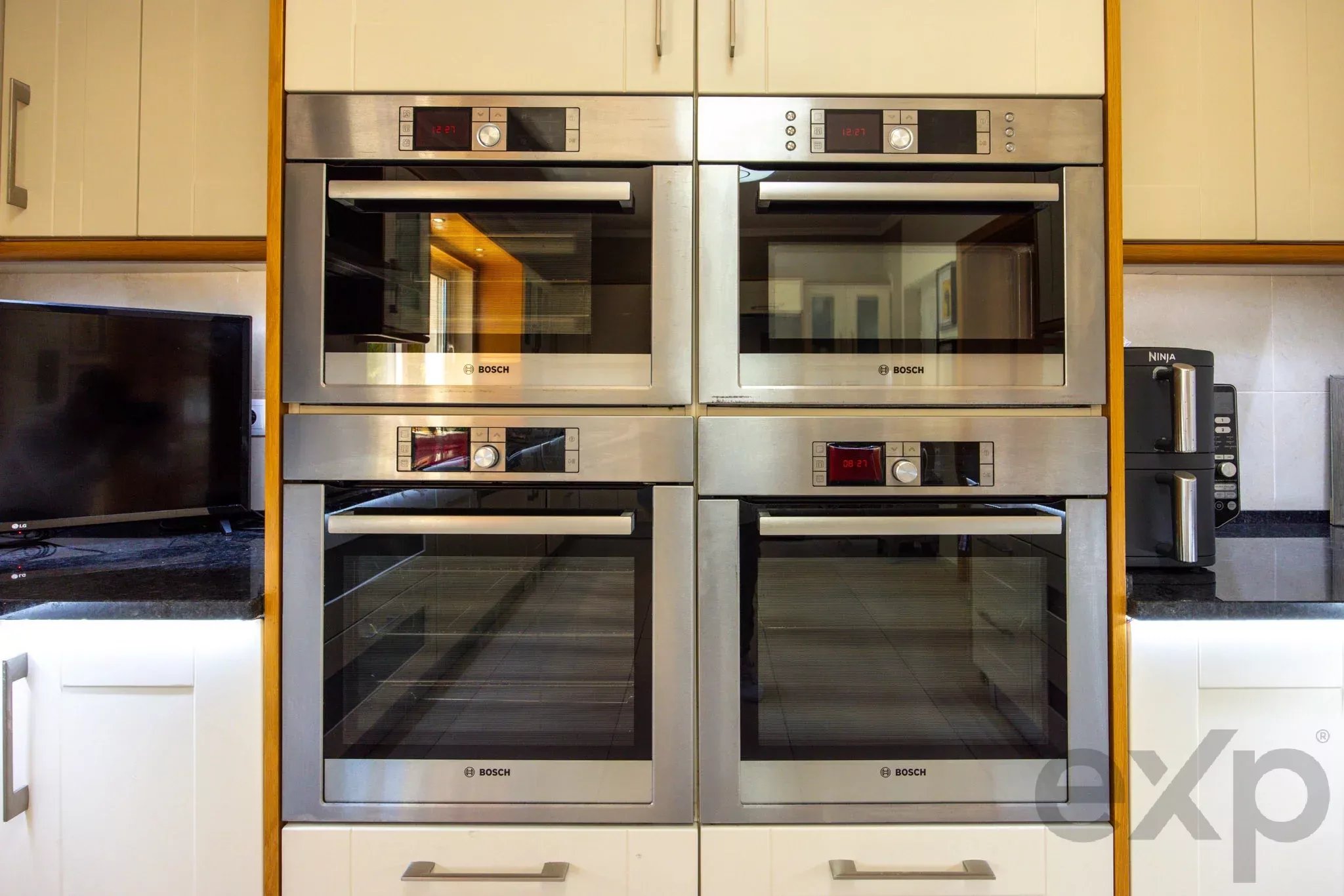 Row of Bosch stainless steel built-in ovens in a modern kitchen setting