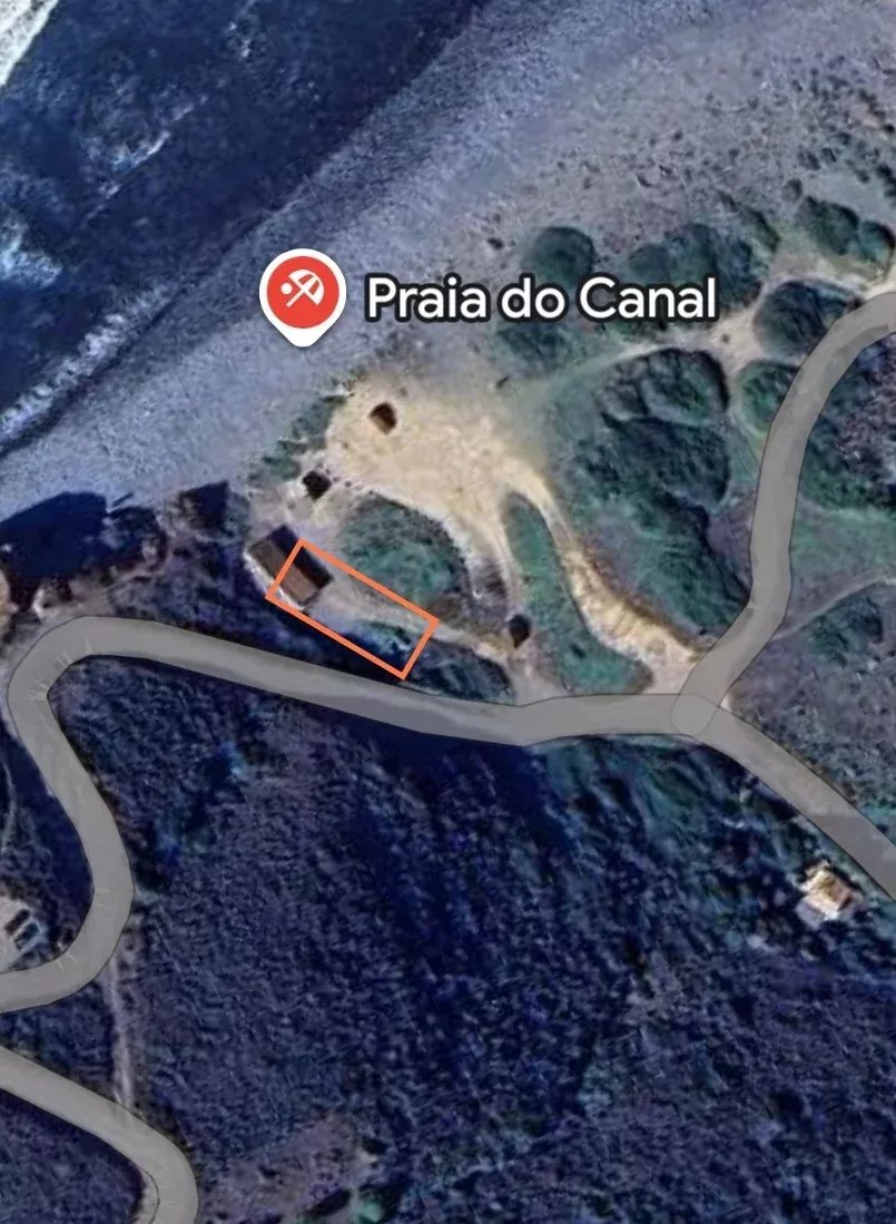 Satellite view of a coastal area labeled Praia do Canal with an orange rectangle highlighting a small building near a winding road by the shore.
