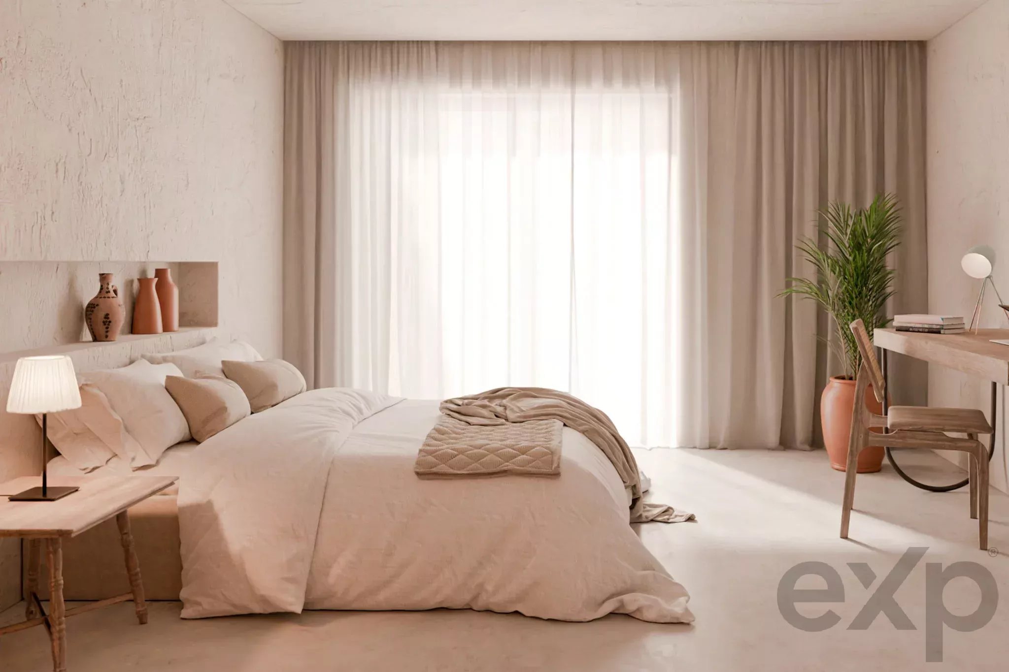 Bright neutral bedroom with a large bed, sheer white curtains, and a tall plant by a desk.