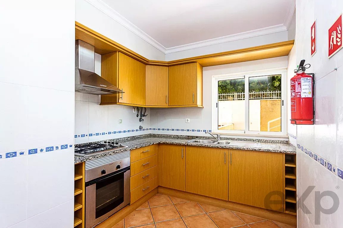 U-shaped kitchen with light wood cabinets, granite counters, gas stove and oven, and a window over the sink.