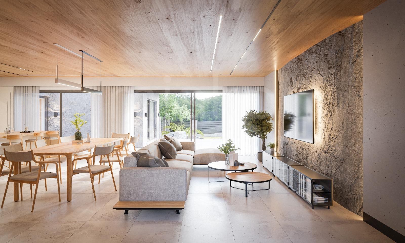 Open-concept living and dining room with a gray sectional, wooden dining table, and large sliding glass doors to a courtyard.