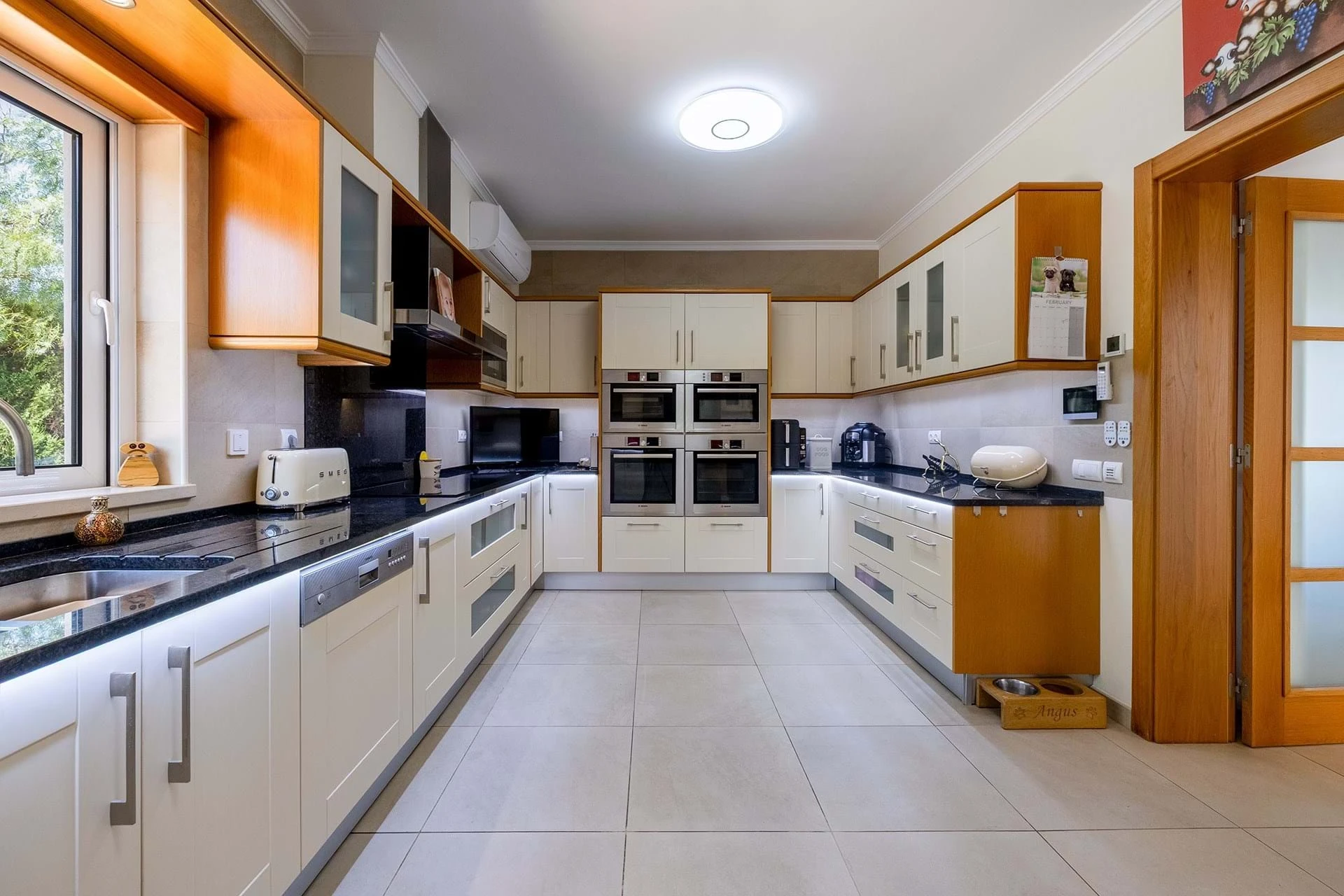 T5 Villa with pool in Ferrel 5mn from beach and Lagos centre – SunnySteve 17 Modern galley kitchen with white cabinets, black countertops, and stainless steel double ovens at center