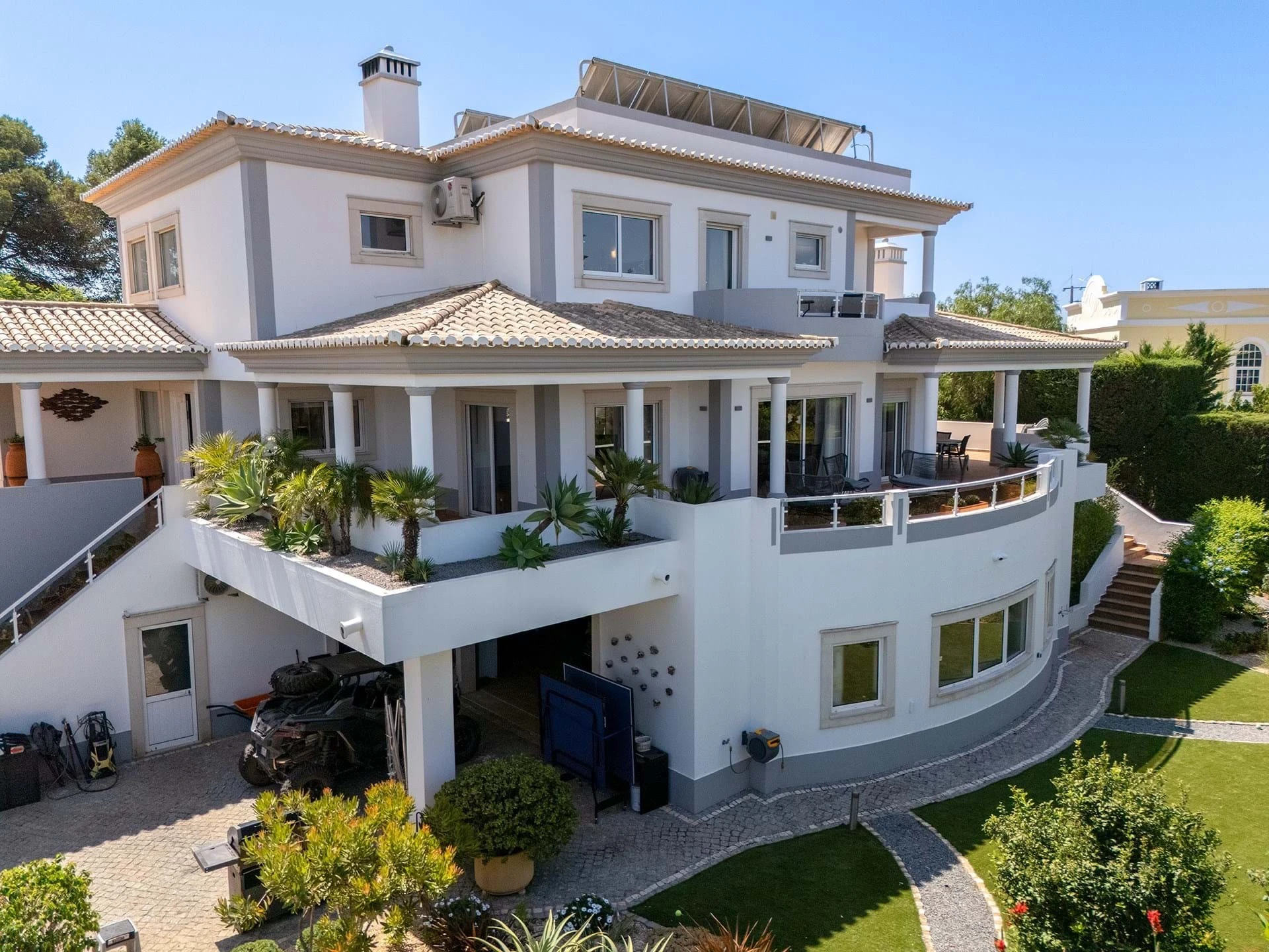T5 Villa with pool in Ferrel 5mn from beach and Lagos centre – SunnySteve 3 Modern white villa with tiled roof, solar panels, and a curved garden path.