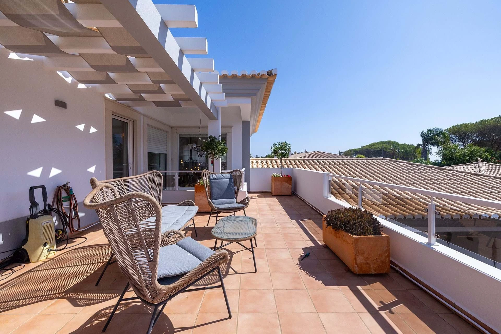 T5 Villa with pool in Ferrel 5mn from beach and Lagos centre – SunnySteve 32 Sunny rooftop terrace with wicker seating, glass table, and potted plants along a white railing beneath a clear blue sky.