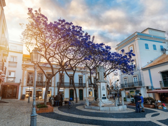 Praca Luis de Camoes in Lagos old town, Algarve, with jacaranda trees in bloom over the calcada pavement