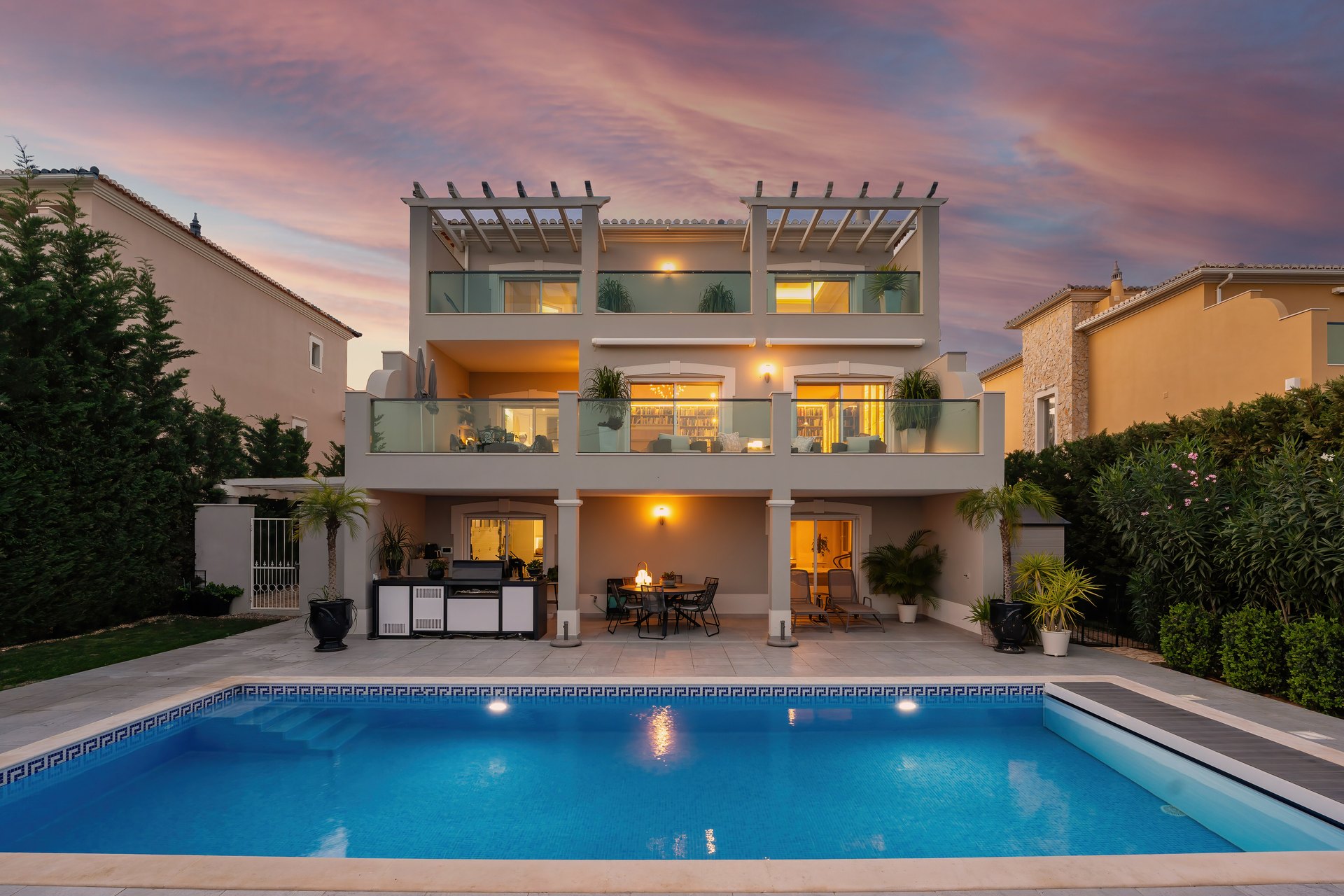Three-storey villa with a lit swimming pool and terraces at dusk in the Algarve, the kind of home whose selling costs this 2026 guide breaks down