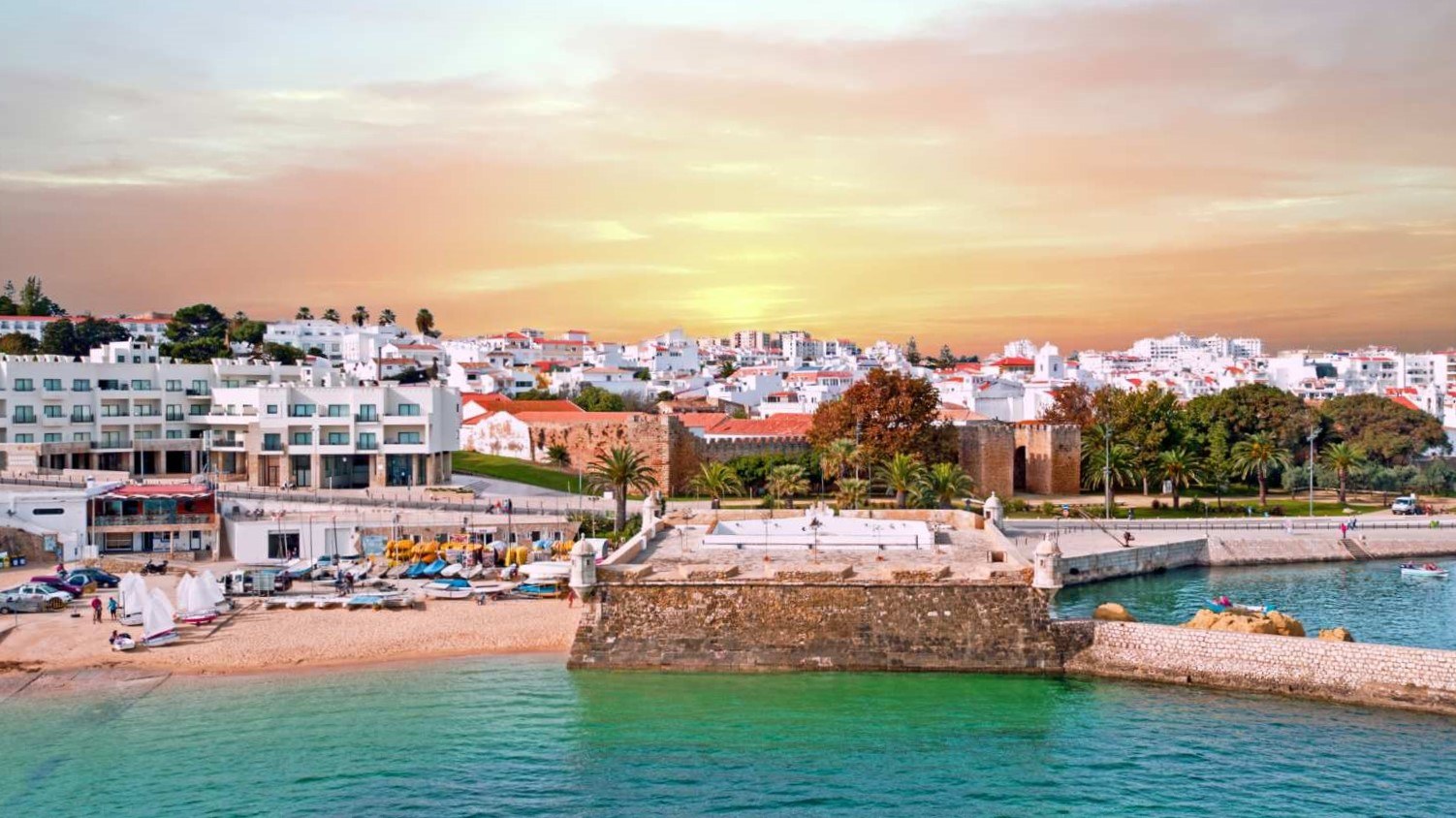 Sunset over Lagos, Portugal, with the Bandeira fort and holiday apartments on the waterfront, where holiday let rental yields average around 4.8% net in 2026