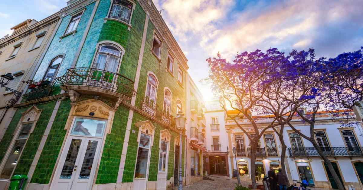 Tiled townhouses and jacaranda trees in Lagos old town, Algarve, where foreign buyers are asking whether Portugal will restrict property purchases in 2026