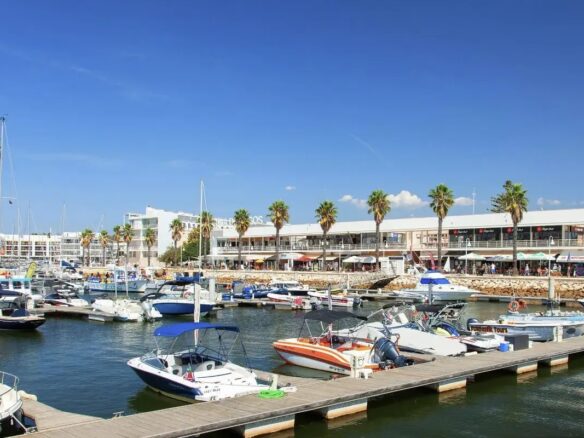 Marina de Lagos in the Algarve with apartments behind the boats, illustrating rental income tax for non-resident landlords in Portugal