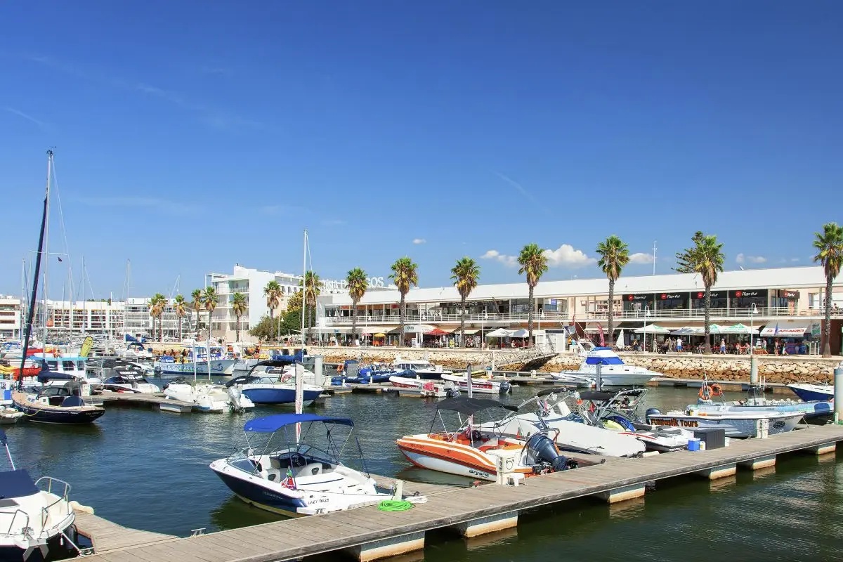 Marina de Lagos in the Algarve with apartments behind the boats, illustrating rental income tax for non-resident landlords in Portugal